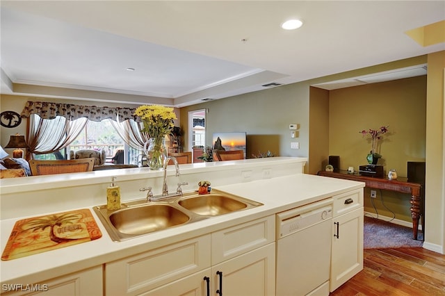 kitchen featuring light countertops, open floor plan, a sink, light wood-type flooring, and dishwasher