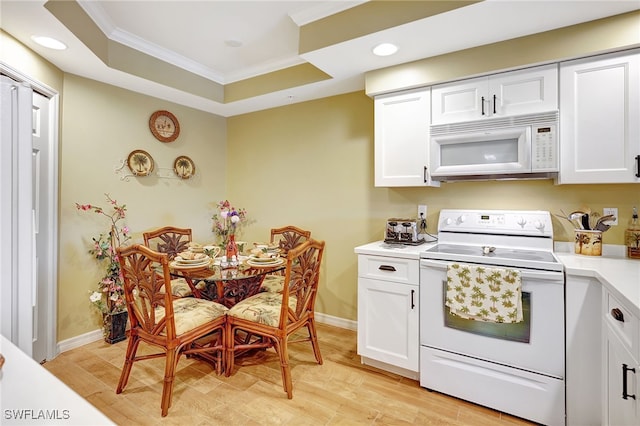 kitchen with white appliances, white cabinetry, light countertops, and ornamental molding