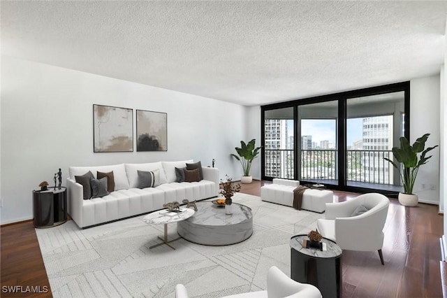 living room with a textured ceiling, wood finished floors, baseboards, and expansive windows