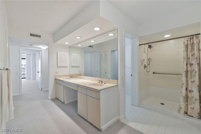 bathroom with visible vents, tiled shower, double vanity, recessed lighting, and a sink