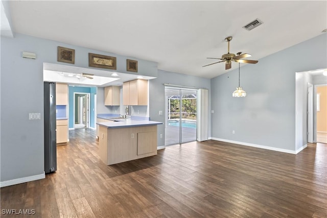 kitchen with dark wood-style floors, light countertops, visible vents, a ceiling fan, and a peninsula