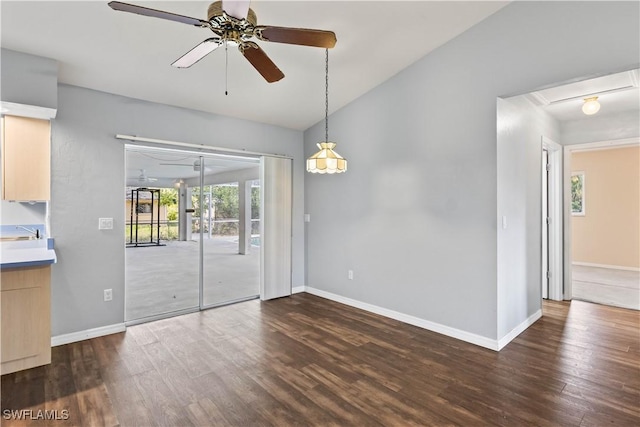 unfurnished room featuring lofted ceiling, baseboards, dark wood finished floors, and a ceiling fan