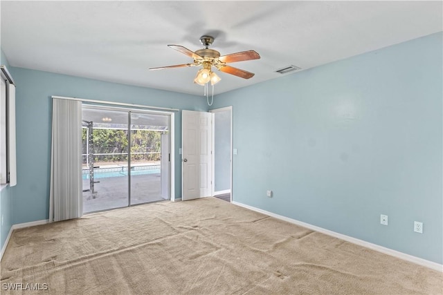 unfurnished room featuring carpet floors, visible vents, ceiling fan, and baseboards