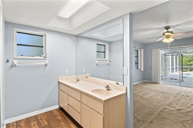 full bath featuring a ceiling fan, a sink, baseboards, and double vanity