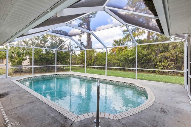 pool with a patio, a yard, and glass enclosure