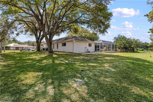 view of yard featuring glass enclosure and fence