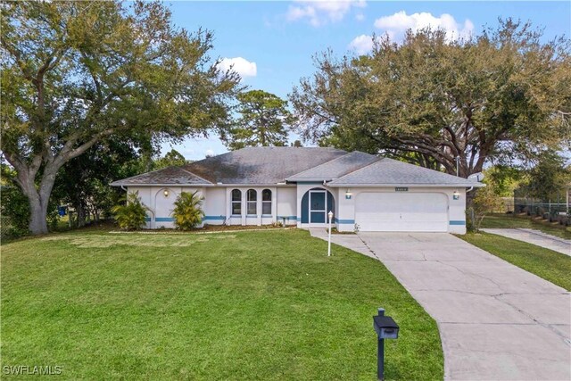 single story home with a garage, concrete driveway, a front lawn, and stucco siding