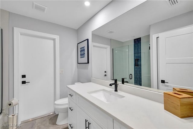 bathroom featuring toilet, vanity, a shower stall, and visible vents