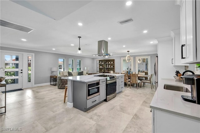 kitchen featuring extractor fan, a kitchen island, white cabinets, appliances with stainless steel finishes, and a kitchen bar