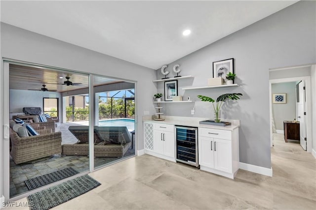 bar featuring beverage cooler, lofted ceiling, a sunroom, and baseboards