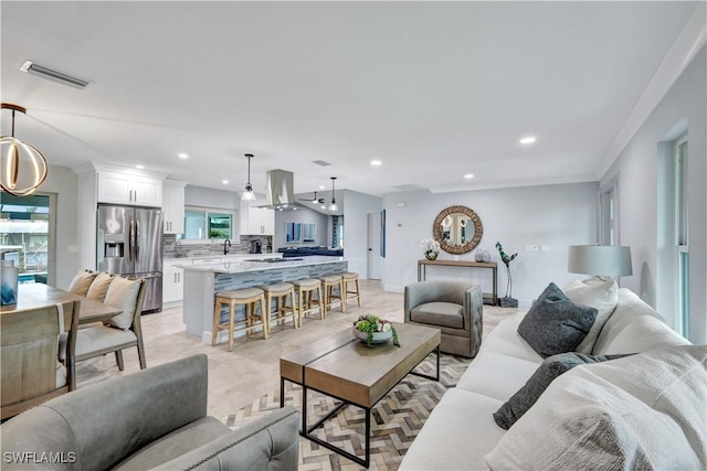 living area with a healthy amount of sunlight, visible vents, and recessed lighting