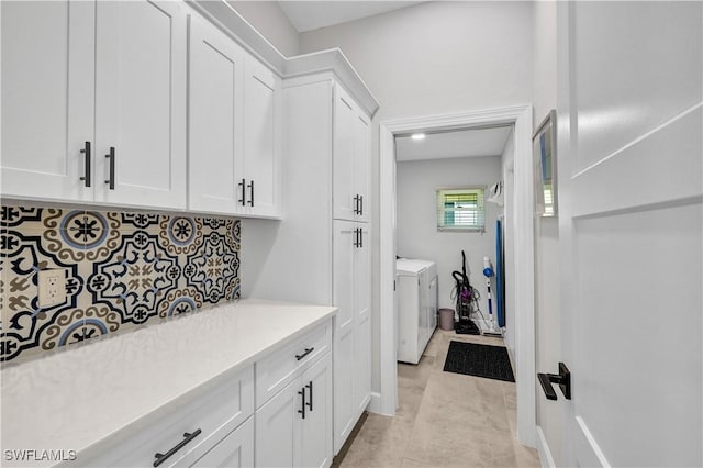 interior space featuring light tile patterned floors, laundry area, baseboards, and washer and dryer