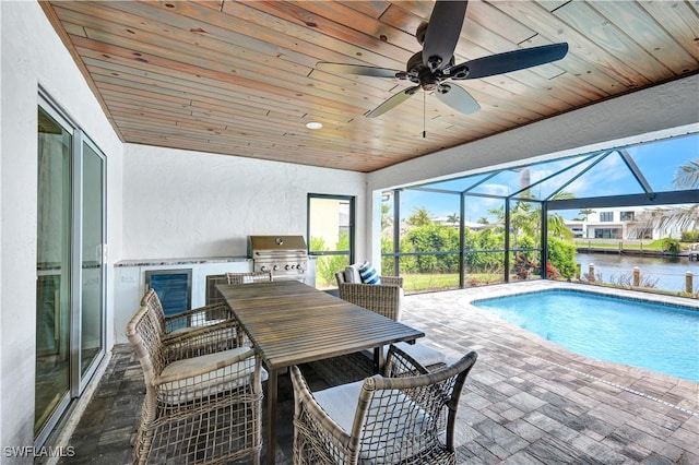 pool featuring a patio, glass enclosure, area for grilling, a ceiling fan, and grilling area