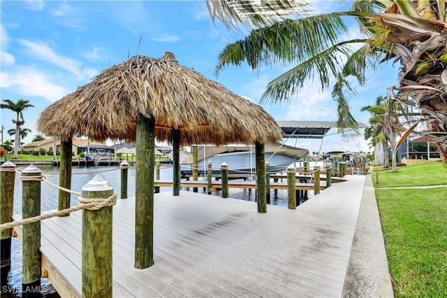 dock area with a lawn, a water view, and boat lift