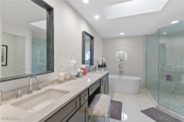 full bathroom with a shower stall, a freestanding bath, a skylight, and a sink