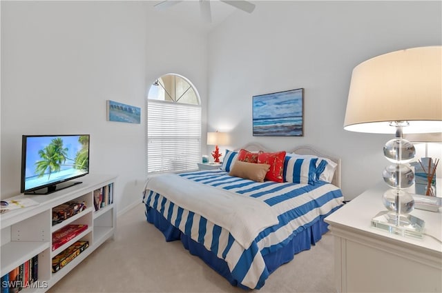 carpeted bedroom with a high ceiling and ceiling fan