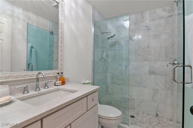 bathroom featuring a shower stall, toilet, and vanity