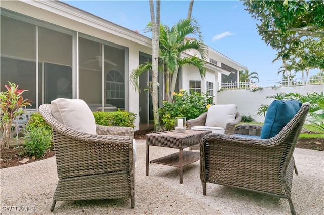 view of patio with outdoor lounge area, fence, and a sunroom