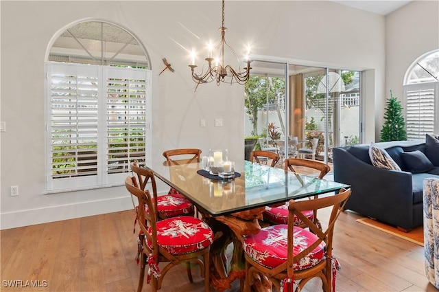 dining space with plenty of natural light, a chandelier, and hardwood / wood-style flooring