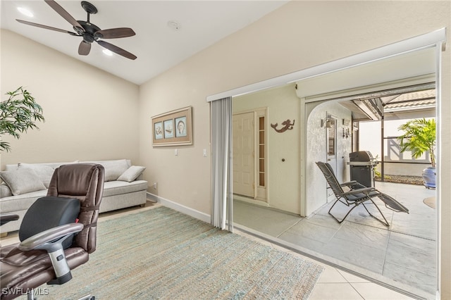 office area featuring a ceiling fan, lofted ceiling, light tile patterned flooring, and baseboards