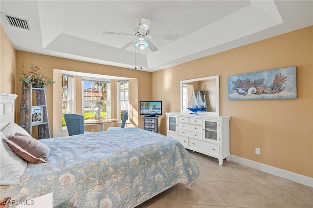 tiled bedroom featuring a ceiling fan, a raised ceiling, visible vents, and baseboards