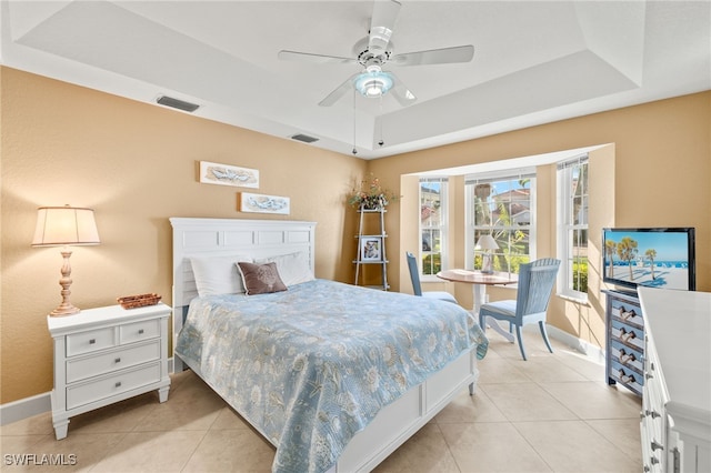 bedroom featuring light tile patterned floors, visible vents, and a raised ceiling