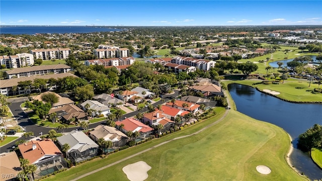 drone / aerial view with view of golf course, a water view, and a residential view