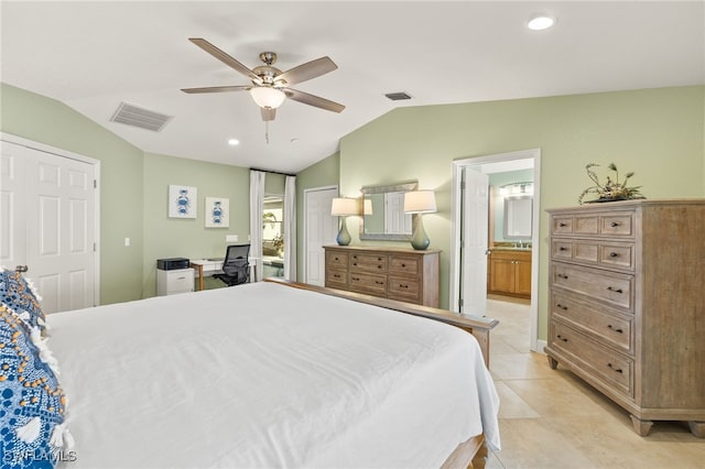 bedroom with lofted ceiling, light tile patterned floors, visible vents, and ensuite bathroom