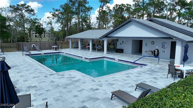 pool with a patio and fence