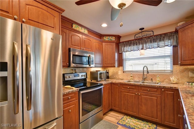 kitchen featuring a sink, brown cabinetry, and stainless steel appliances