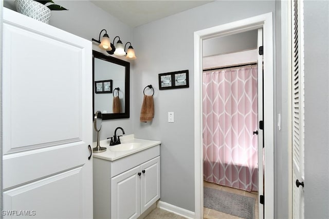 bathroom with curtained shower, baseboards, and vanity