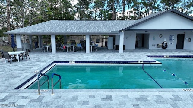 community pool featuring a patio, fence, and outdoor dry bar