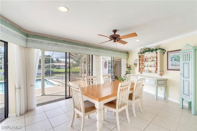 dining space with ornamental molding, light tile patterned flooring, and baseboards