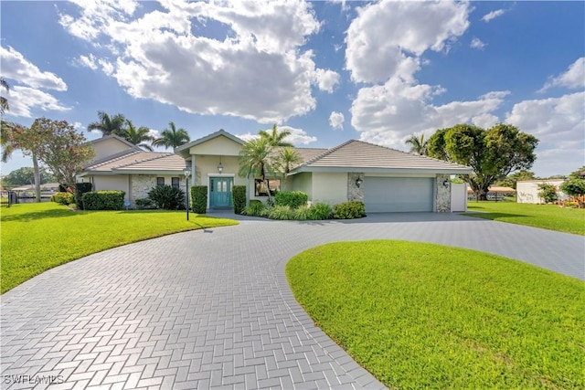 ranch-style house featuring a front lawn, decorative driveway, an attached garage, and stucco siding