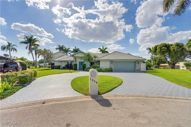 ranch-style house with a front yard, decorative driveway, an attached garage, and stucco siding