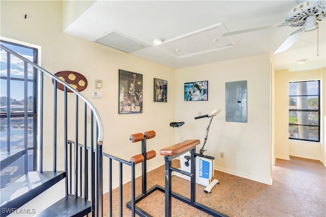 exercise area featuring attic access, electric panel, and baseboards