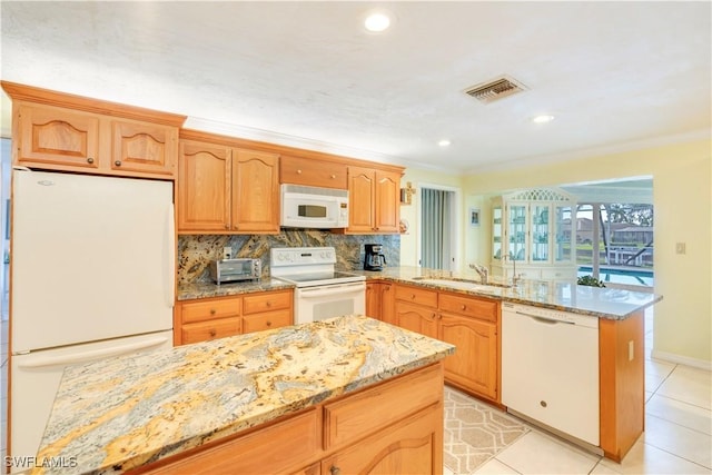 kitchen featuring white appliances, visible vents, decorative backsplash, light stone counters, and a peninsula