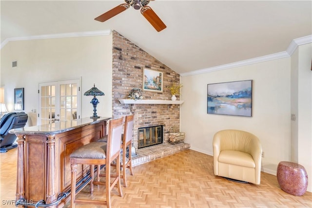 interior space with ornamental molding, french doors, a brick fireplace, and baseboards