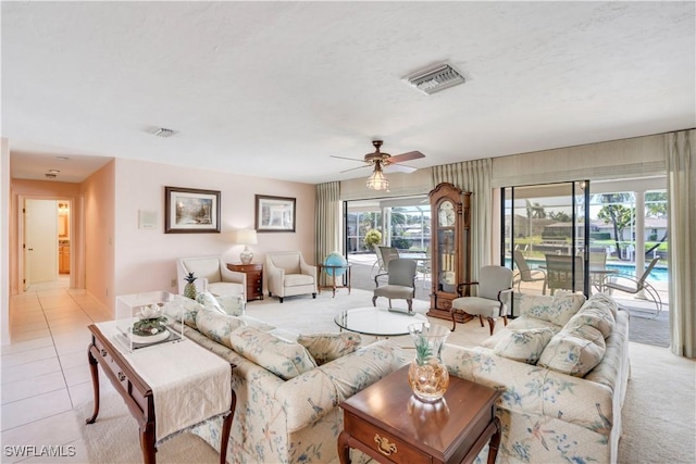 living area with light tile patterned floors, visible vents, and a ceiling fan