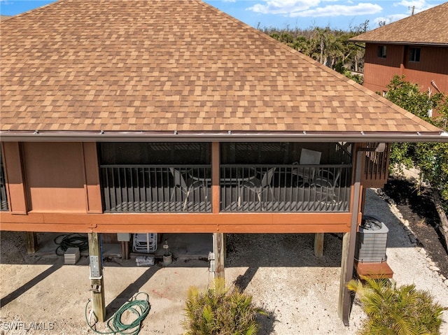 exterior space featuring roof with shingles