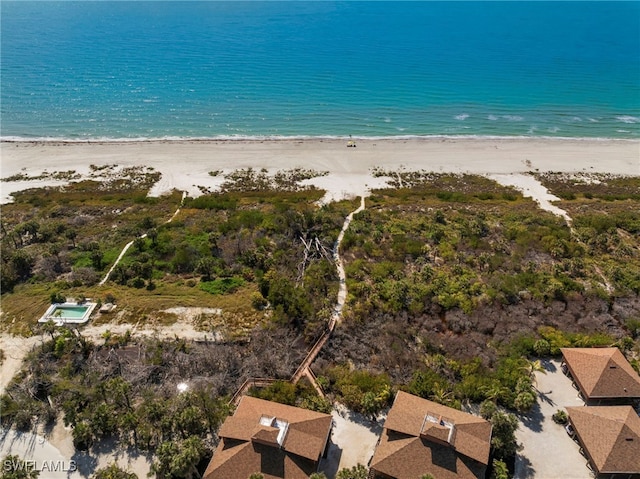 birds eye view of property with a water view and a beach view