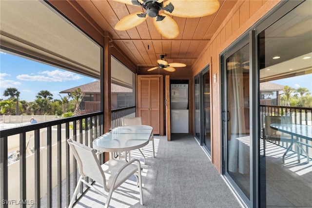 balcony featuring stacked washer / dryer and a ceiling fan