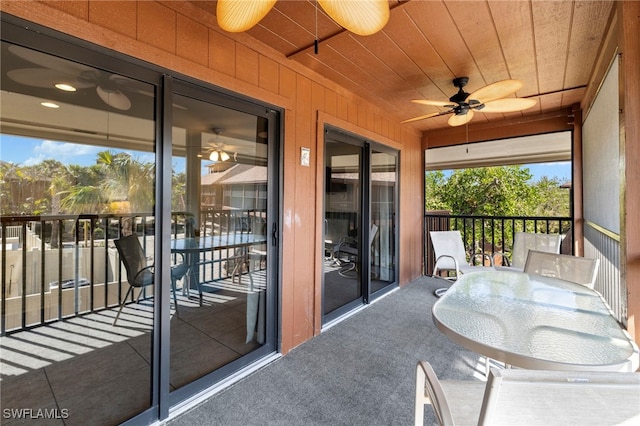 balcony with outdoor dining area and ceiling fan