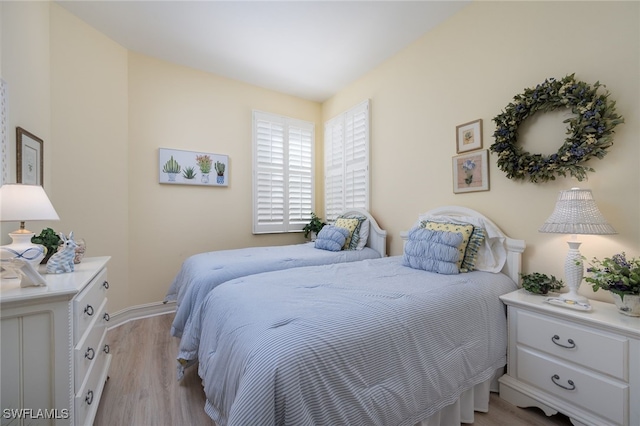 bedroom featuring light wood-style flooring and baseboards