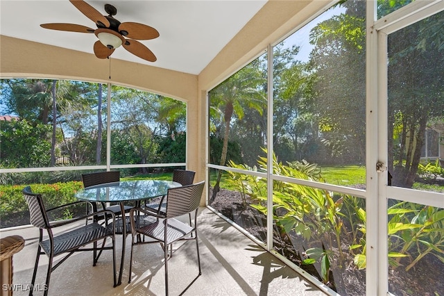 unfurnished sunroom featuring ceiling fan