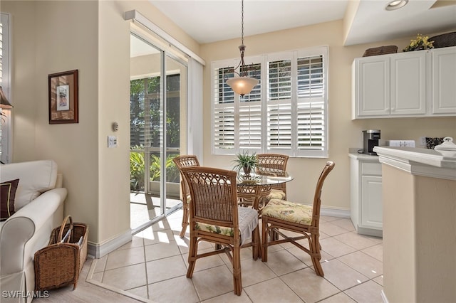 dining space featuring light tile patterned floors and baseboards