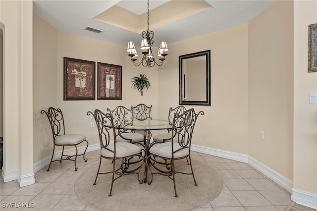 dining area featuring light tile patterned floors, a chandelier, visible vents, and baseboards