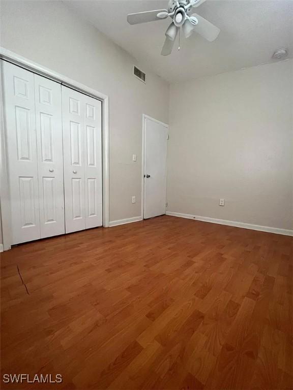 unfurnished bedroom featuring a ceiling fan, baseboards, visible vents, and light wood-type flooring