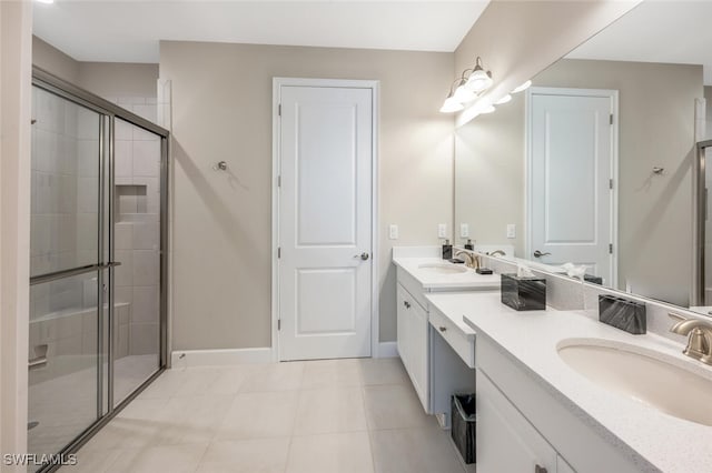 bathroom featuring double vanity, baseboards, tile patterned flooring, a shower stall, and a sink