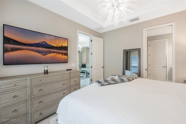 bedroom featuring a tray ceiling, visible vents, and a notable chandelier